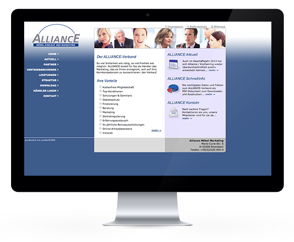Laptop zeigt die Webseite von Alliance Möbel Marketing mit einem Teamfoto und Kontaktmöglichkeit.