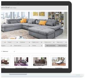 Laptop-Bildschirm zeigt ein graues L-förmiges Sofa mit orangefarbenen Kissen.