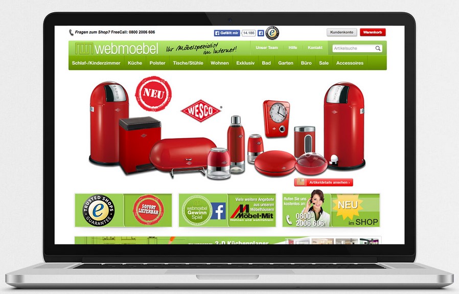 Laptop zeigt eine Webseite für Küchenmöbel mit dem Titel "webmoebel" und verschiedenen Artikeln wie einem roten Wesco Müllbecken.